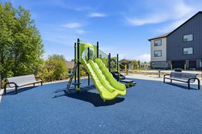 Dubuque apartment for rent - A playground with a green slide and a blue surface.