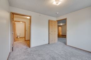Bloomington apartment for rent - A bedroom with a carpeted floor and a walk-through closet to the bathroom.