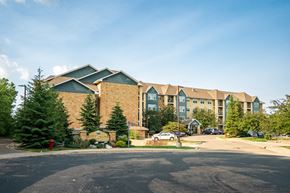 Maple Grove apartment for rent - A large building with a parking lot in front of it.