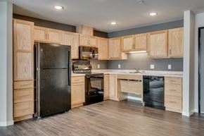 St. Michael apartment for rent - a kitchen with wooden cabinets and a black refrigerator