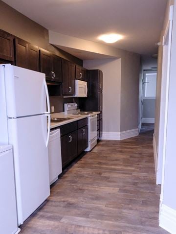St Paul apartment for rent - A kitchen with a white refrigerator and wooden cabinets.