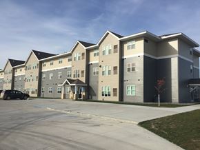 Roseau apartment for rent - A large apartment complex with multiple buildings and a parking lot in front.