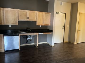 St Paul apartment for rent - A kitchen with wooden cabinets and a black countertop.