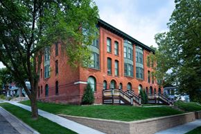 St Paul apartment for rent - A red brick building with green trees in front.