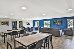 Kasson apartment for rent - A room with tables and chairs and a blue wall.