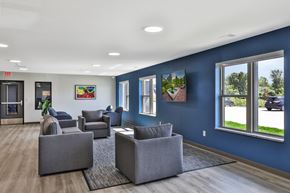 Kasson apartment for rent - A spacious waiting room with grey couches and a view of the street outside.