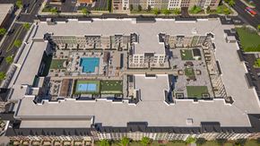 West Hempstead townhouse for rent - A large, open courtyard surrounded by buildings with a pool and a tennis court.