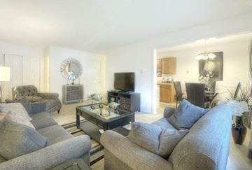 Rochester apartment for rent - A living room with grey couches and a television.