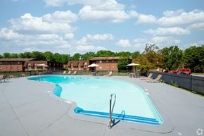 Rochester apartment for rent - A large swimming pool with a diving board in the middle.