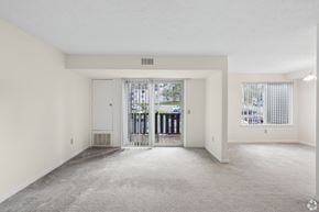 Fairport townhouse for rent - A spacious, empty room with a carpeted floor and white walls.