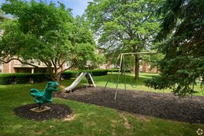Rochester apartment for rent - A playground with a green slide and a brown mulch area.
