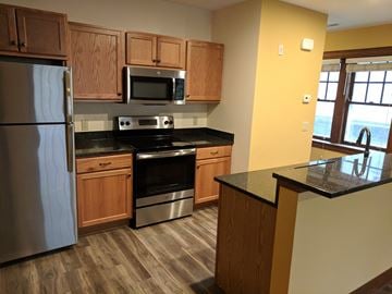 Madison apartment for rent - A kitchen with wooden cabinets and a black countertop.