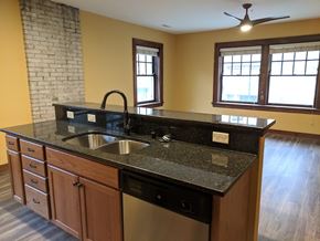Madison apartment for rent - A kitchen with a black granite countertop and wooden cabinets.
