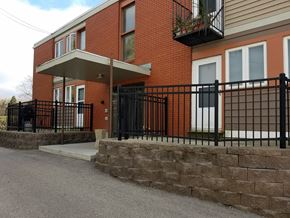 Monona apartment for rent - A red brick house with a black iron fence.