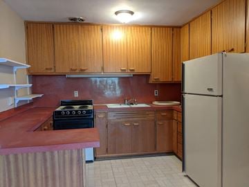 Monona apartment for rent - A kitchen with wooden cabinets and a refrigerator.