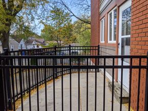 Monona apartment for rent - A black metal fence surrounds a brick building.