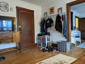 Madison apartment for rent - A room with a wooden floor and a white wall with a coat rack and a white chair.
