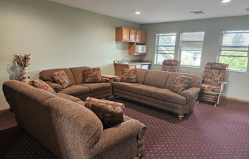 Waunakee apartment for rent - A living room with brown couches and a red carpet.