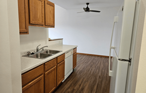 Waunakee apartment for rent - A kitchen with wooden cabinets and a white fridge.