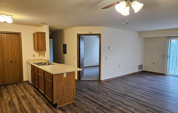 Waunakee apartment for rent - A kitchen with wooden cabinets and a countertop is shown.