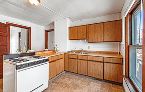 Madison apartment for rent - A kitchen with wooden cabinets and a white stove top oven.