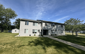 New Glarus apartment for rent - A large grey house with a white door and windows.