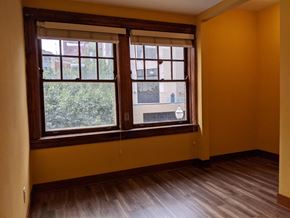 Madison apartment for rent - A room with a window and wooden floors.