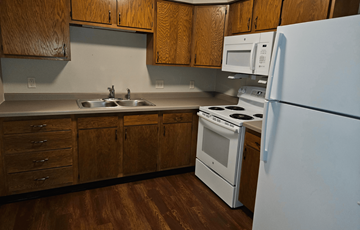 Mineral Point apartment for rent - a kitchen with white appliances and wooden cabinets