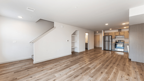 Lac Du Flambeau apartment for rent - A spacious room with wooden flooring and a staircase leading to another level.