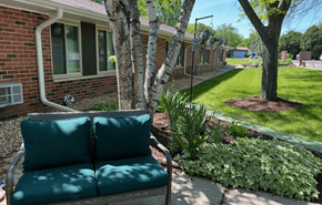 Cambridge apartment for rent - A green couch is in the foreground of a sunny backyard.