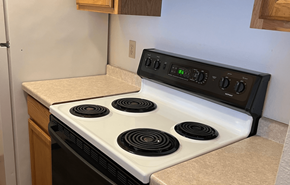 Cambridge apartment for rent - A white stove top with four burners and a control panel above it.