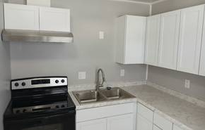 Leroy apartment for rent - A kitchen with a black stove top oven and white cabinets.
