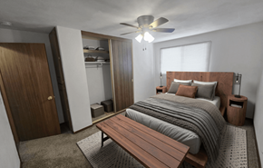 Sun Prairie apartment for rent - A bedroom with a bed, a bench, and a ceiling fan.
