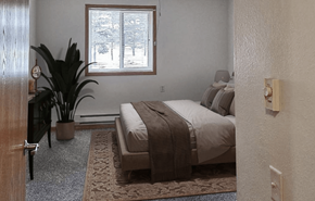Rothschild apartment for rent - A bedroom with a bed, a potted plant, and a window.