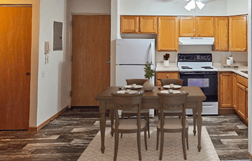 Rothschild apartment for rent - A kitchen with a table set for two with a refrigerator and oven in the background.