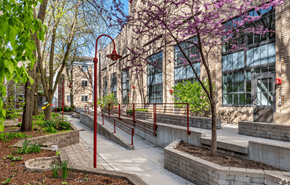 Madison apartment for rent - A walkway with red railings and trees in front of a building.