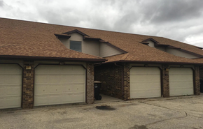 Deforest apartment for rent - A house with a brown roof and three garage doors.