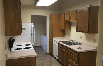 Deforest apartment for rent - A kitchen with a white stove top oven and white refrigerator.