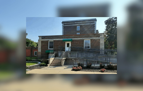 Beloit apartment for rent - A brick building with a green door and steps leading up to it.