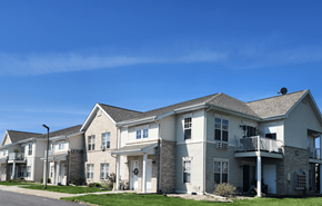 Reedsburg apartment for rent - A row of houses with a clear blue sky above them.