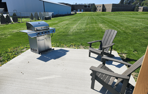 Reedsburg apartment for rent - A BBQ grill is on a patio with two chairs.