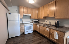 Barneveld apartment for rent - A kitchen with wooden cabinets and a white refrigerator.