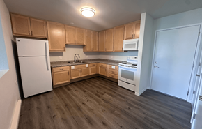 Barneveld apartment for rent - A kitchen with wooden cabinets and a white refrigerator.