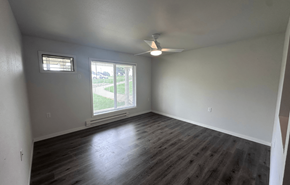 Barneveld apartment for rent - A room with a ceiling fan and a window overlooking a green area.