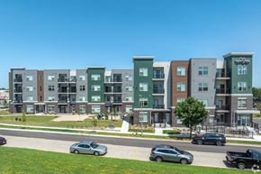 Madison apartment for rent - A row of modern apartment buildings with cars parked in front.