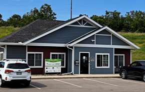 Darlington apartment for rent - A small building with a red and blue exterior is surrounded by a parking lot.