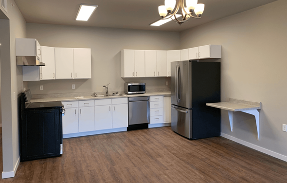 Darlington apartment for rent - A kitchen with white cabinets and a black fridge.