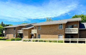 Cross Plains apartment for rent - A large brick building with a white fence in front.