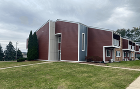 Beloit apartment for rent - A modern building with a red brick exterior and a grey roof.