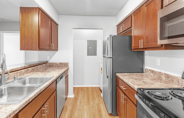 Madison apartment for rent - A kitchen with wooden cabinets and a black refrigerator.